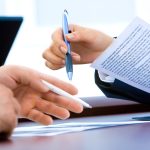 Ondernemer aan bureau met stapel papieren en financiële zorgen