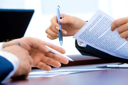 Ondernemer aan bureau met stapel papieren en financiële zorgen