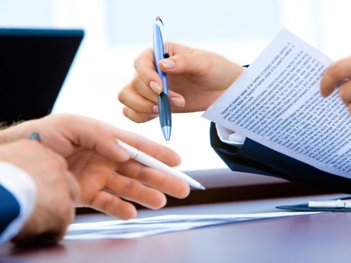 Ondernemer aan bureau met stapel papieren en financiële zorgen