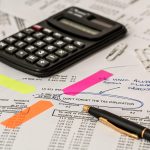 Ondernemer die verzekeringspolissen en documenten doorneemt aan een bureau