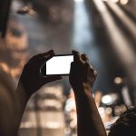Smartphone op statief filmt een product op een witte achtergrond voor een productdemo video