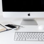 Kleine ondernemer bekijkt social media op smartphone aan bureau