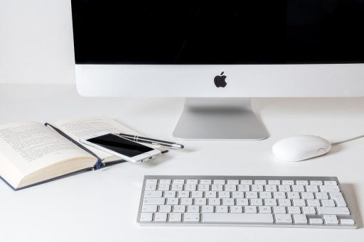 Kleine ondernemer bekijkt social media op smartphone aan bureau