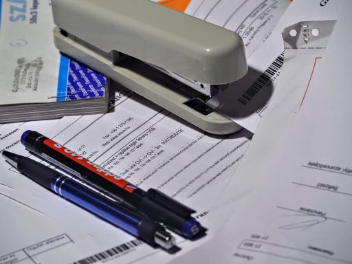 Ondernemer bekijkt openstaande factuur op bureau met laptop en administratie
