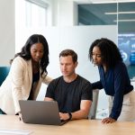 Twee zakelijke professionals bekijken SEO-data op een laptop tijdens een vergadering